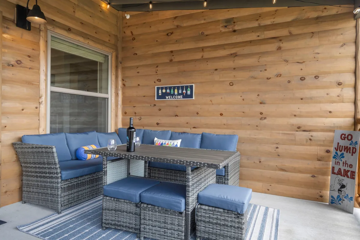 A welcoming exterior space with comfortable outdoor seating and a dining table, accented by a decorative sign. The area is set up for sunset dinners, game nights, and special celebrations, underlining the importance of shared experiences and al fresco dining.