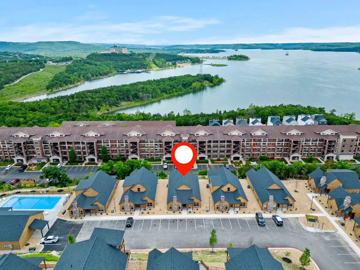 This image captures a serene scene featuring Table Rock Lake, lush surrounding greenery, residential cabins, and a swimming pool. The lakeside setting emphasizes access to water activities and the immersion in nature that the section describes.